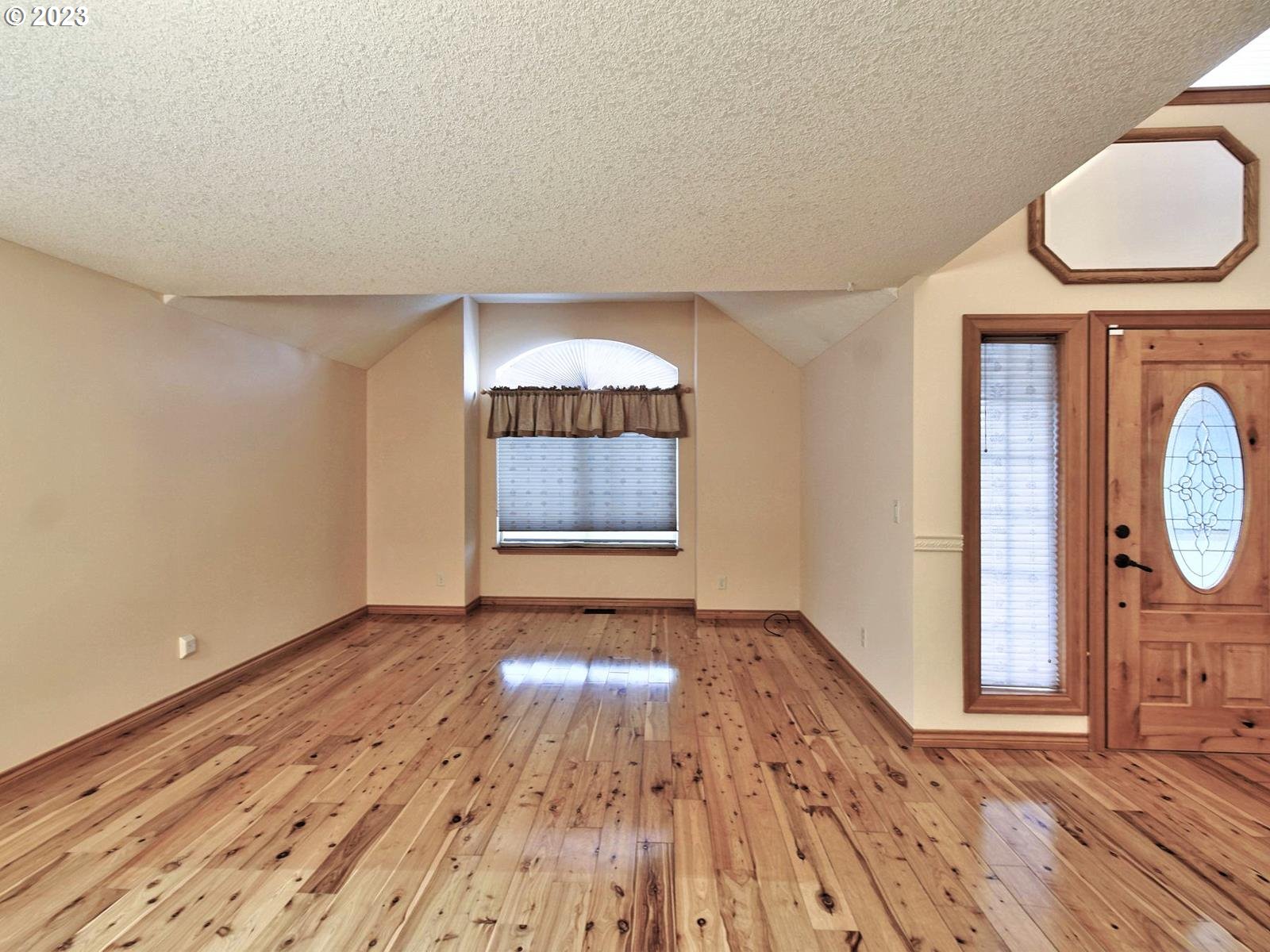 34385 Northeast Sunset Loop Scappoose, OR 97056 - Photo 11 of 42 an empty room with wooden floor mirror and windows
