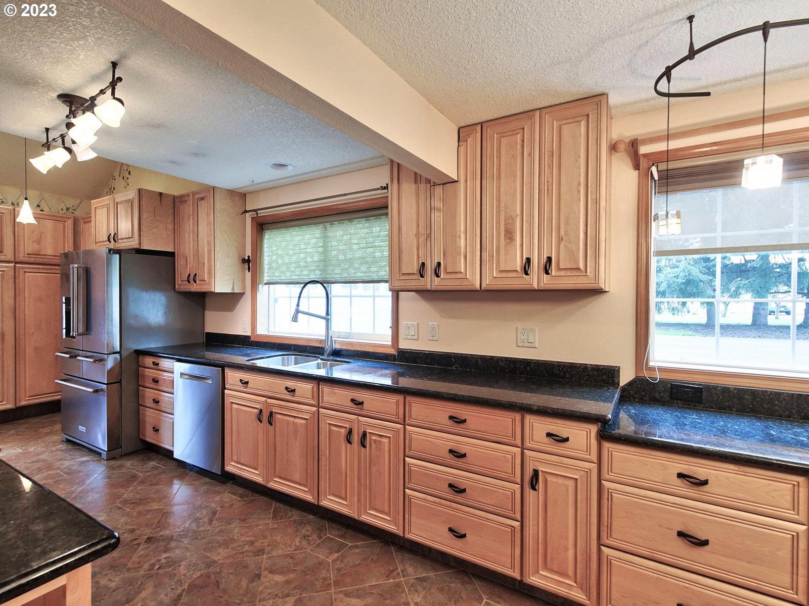 34385 Northeast Sunset Loop Scappoose, OR 97056 - Photo 12 of 42 a kitchen with granite countertop a stove a sink dishwasher and wooden cabinets