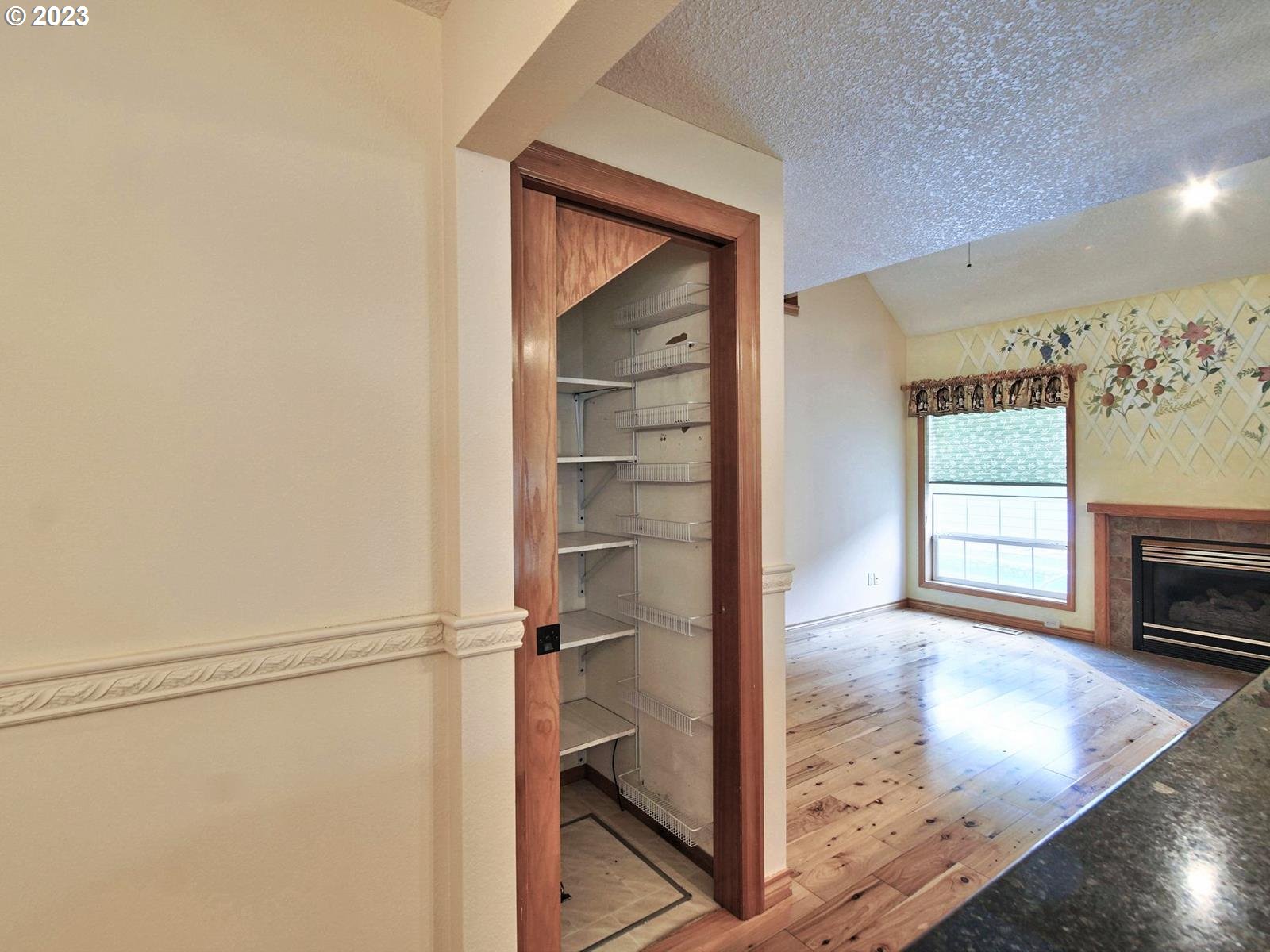 34385 Northeast Sunset Loop Scappoose, OR 97056 - Photo 14 of 42 a view of a hallway to room with wooden floor and cabinet