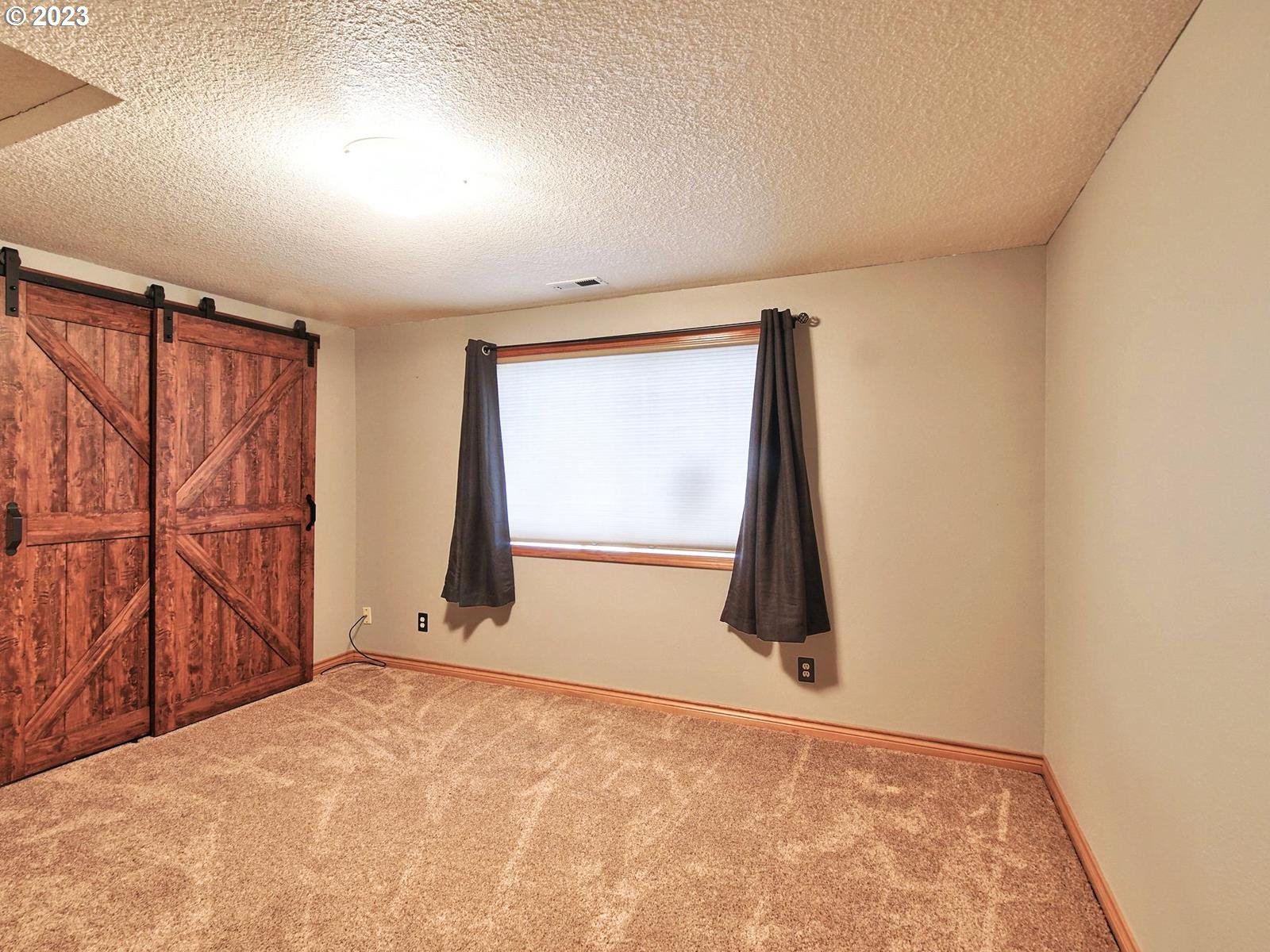 34385 Northeast Sunset Loop Scappoose, OR 97056 - Photo 25 of 42 an empty room with wooden floor and windows
