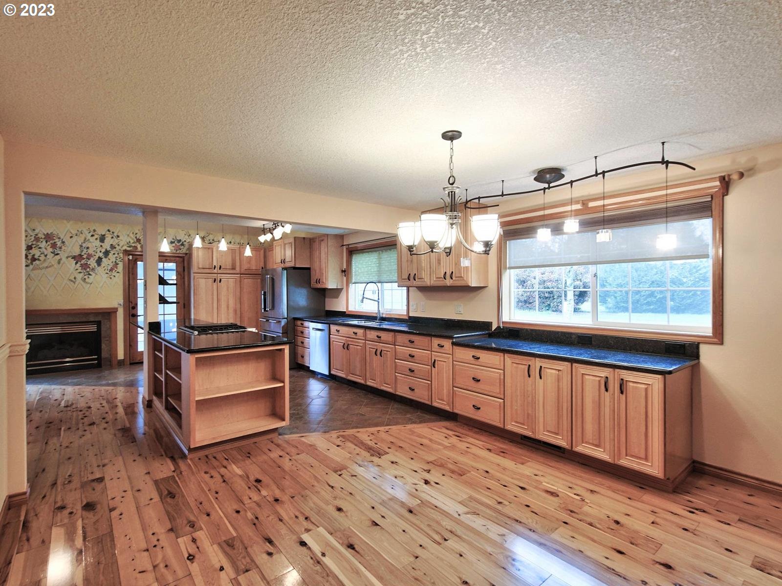 34385 Northeast Sunset Loop Scappoose, OR 97056 - Photo 5 of 42 a large living room with kitchen island furniture and a chandelier