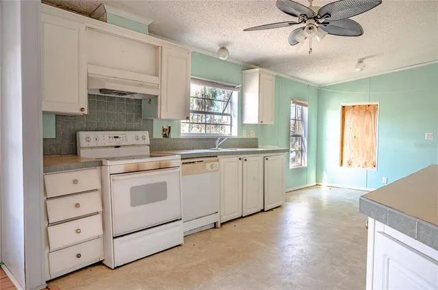 a kitchen with a white cabinets and chandelier