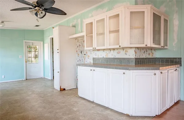 en empty room with windows and ceiling fan