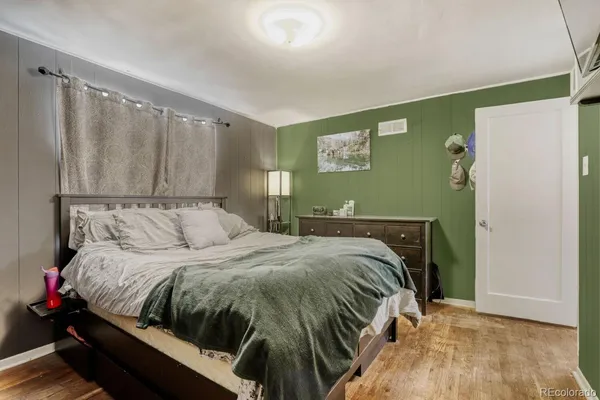 a bedroom with a bed and wooden floor