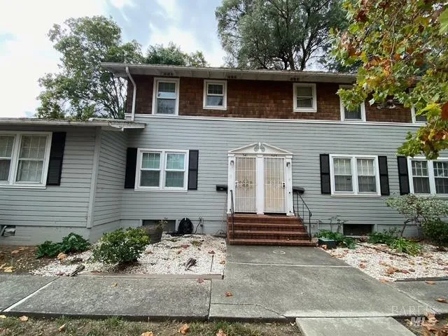 a front view of a house with a tree