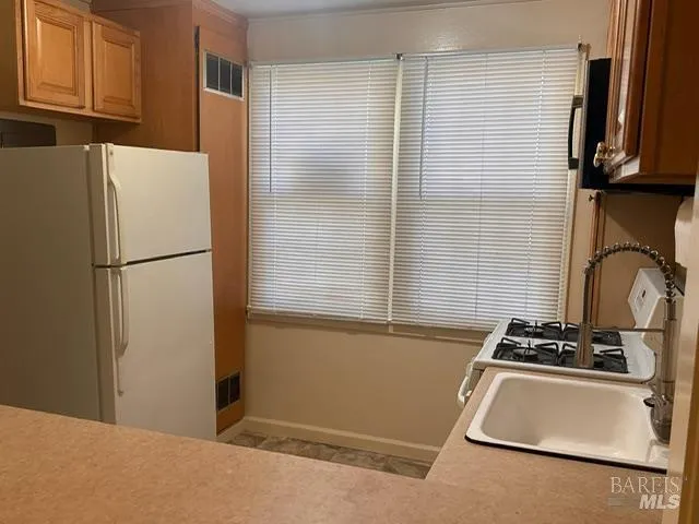 a kitchen with a refrigerator and a stove