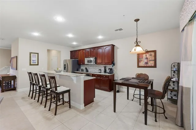 a large kitchen with granite countertop a large counter top stainless steel appliances a sink a stove and cabinets