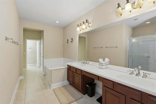 a spacious bathroom with a bathtub sink and mirror