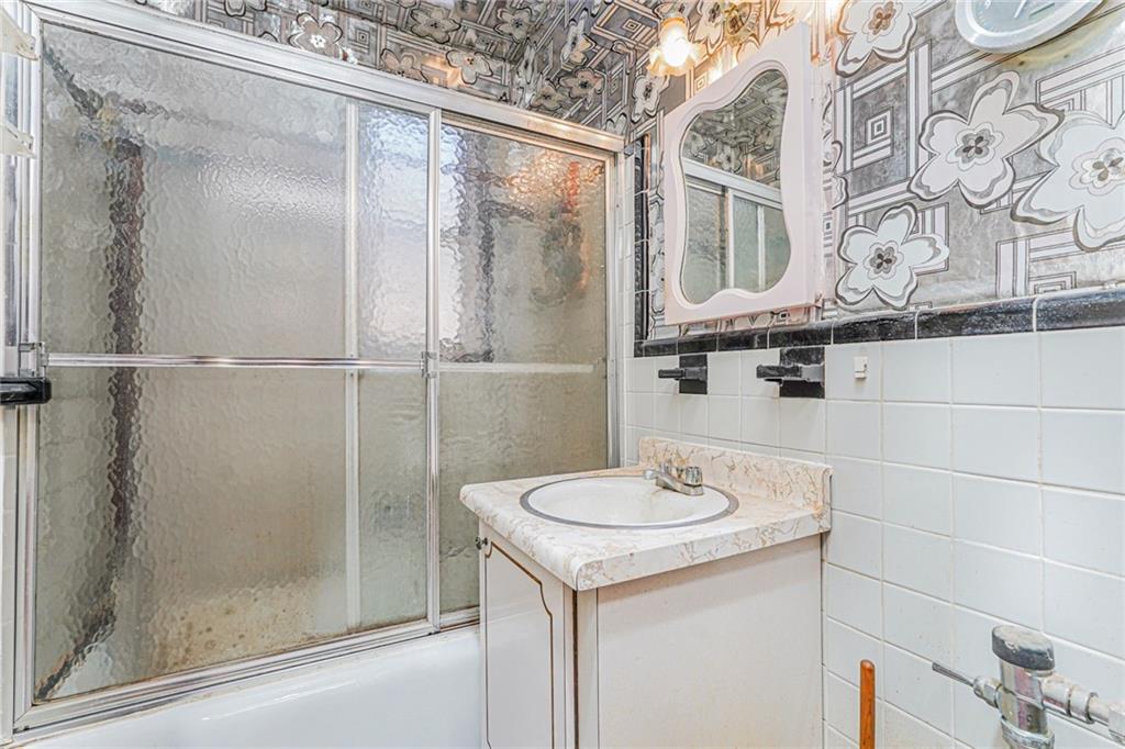 2514 East 7th Street, Unit 6J Brooklyn, NY 11235 - Photo 16 of 17 a bathroom with a sink and a mirror