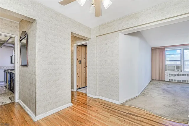 a view of a hallway with wooden floor and closet area