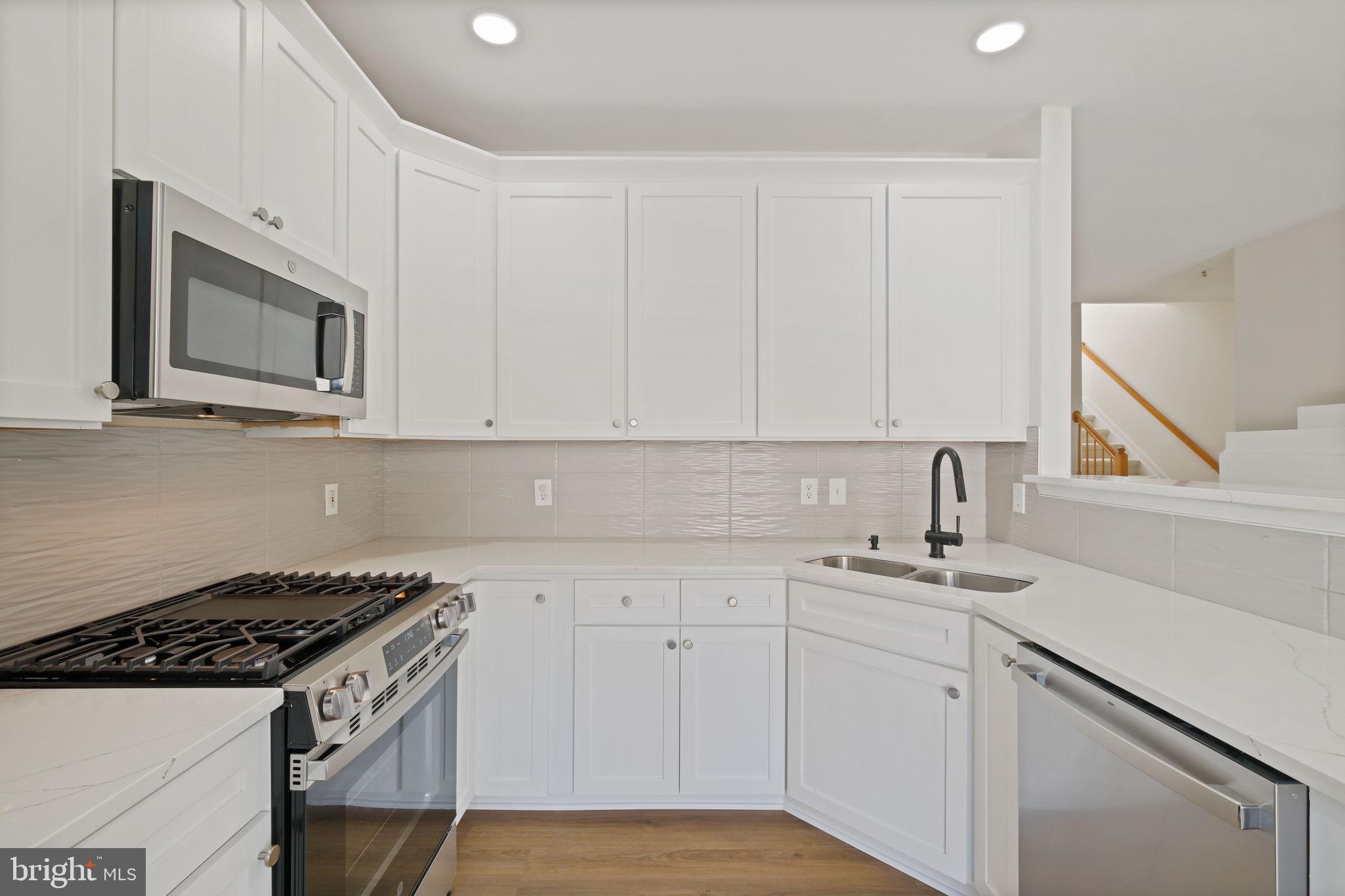 719 Main Street, Unit 719B Gaithersburg, MD 20878 - Photo 13 of 43 a kitchen with white cabinets and appliances