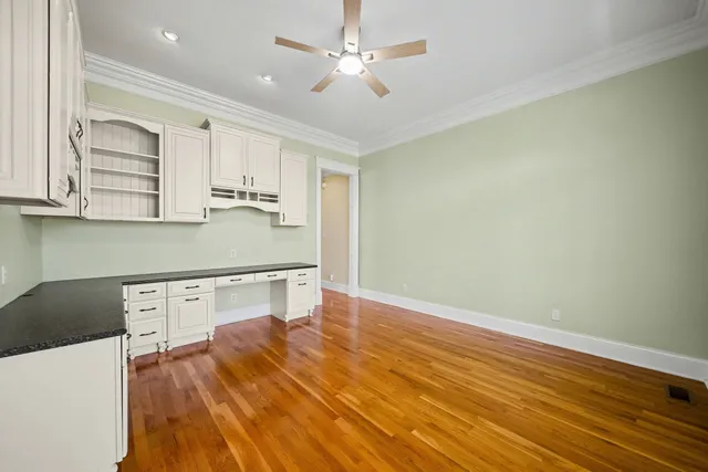 a kitchen with wooden floors and white cabinets