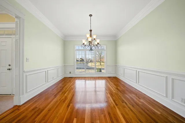 a view of a room with wooden floor and chandelier