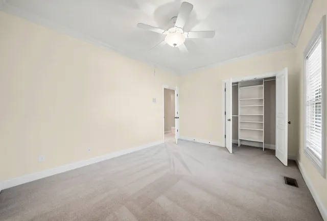 an empty room with a ceiling fan and window