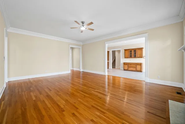 a view of empty room with wooden floor and fan