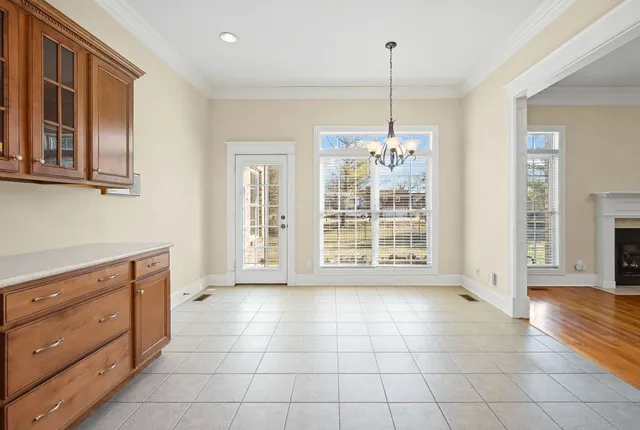 a view of an empty room with a window and kitchen view
