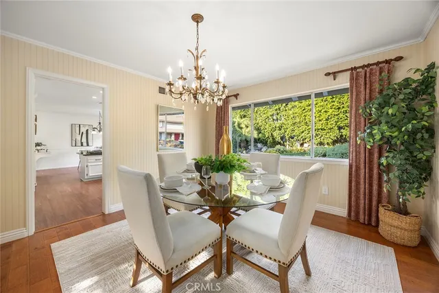 a kitchen with stainless steel appliances granite countertop wooden floor window and chairs