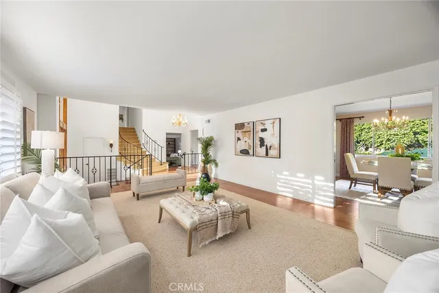 a dining room with furniture a chandelier and wooden floor