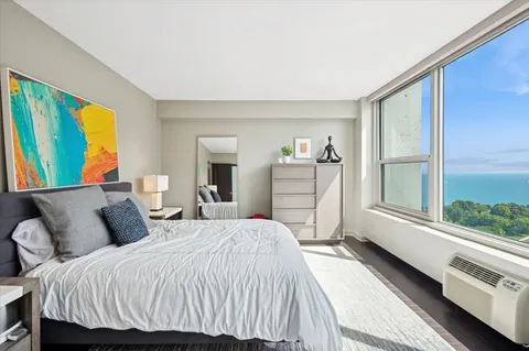 a bedroom with a bed and a large window