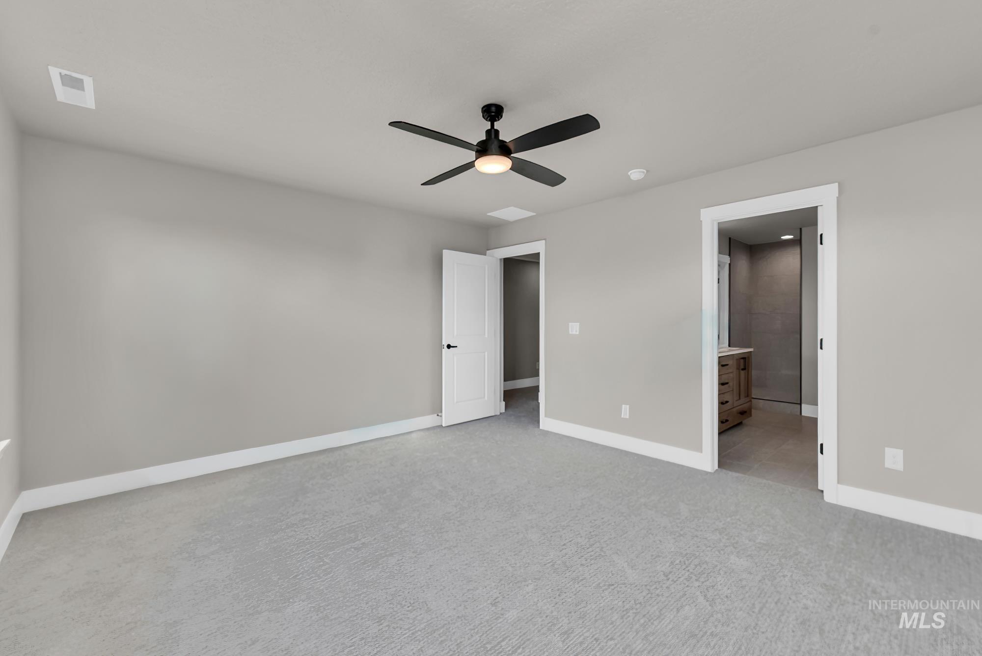2807 West Jutland Street Meridian, ID 83642 - Photo 14 of 25 Unfurnished bedroom featuring light colored carpet, a ceiling fan, and connected bathroom