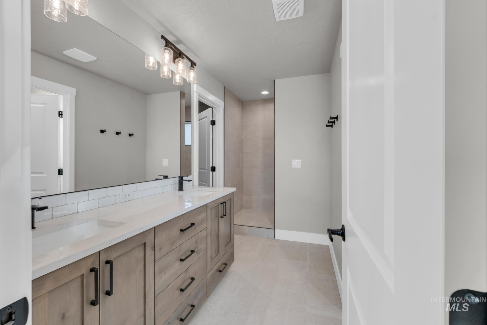 2807 West Jutland Street Meridian, ID 83642 - Photo 15 of 25 Full bathroom with double vanity, walk in shower, recessed lighting, and light tile patterned floors