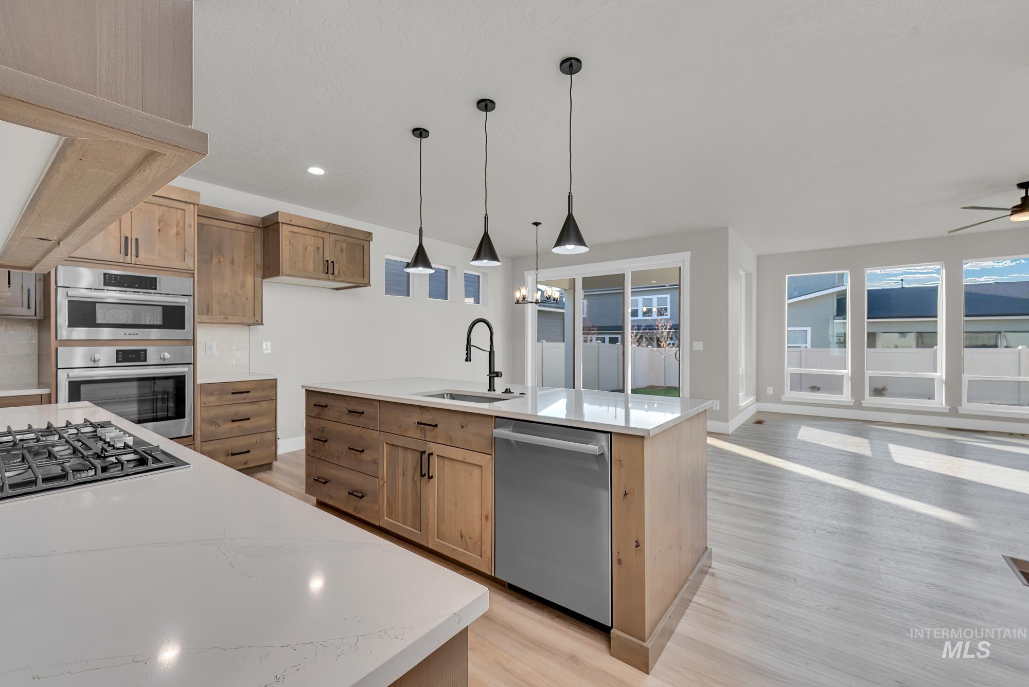2807 West Jutland Street Meridian, ID 83642 - Photo 6 of 25 Kitchen featuring light stone countertops, pendant lighting, light wood-style floors, and recessed lighting