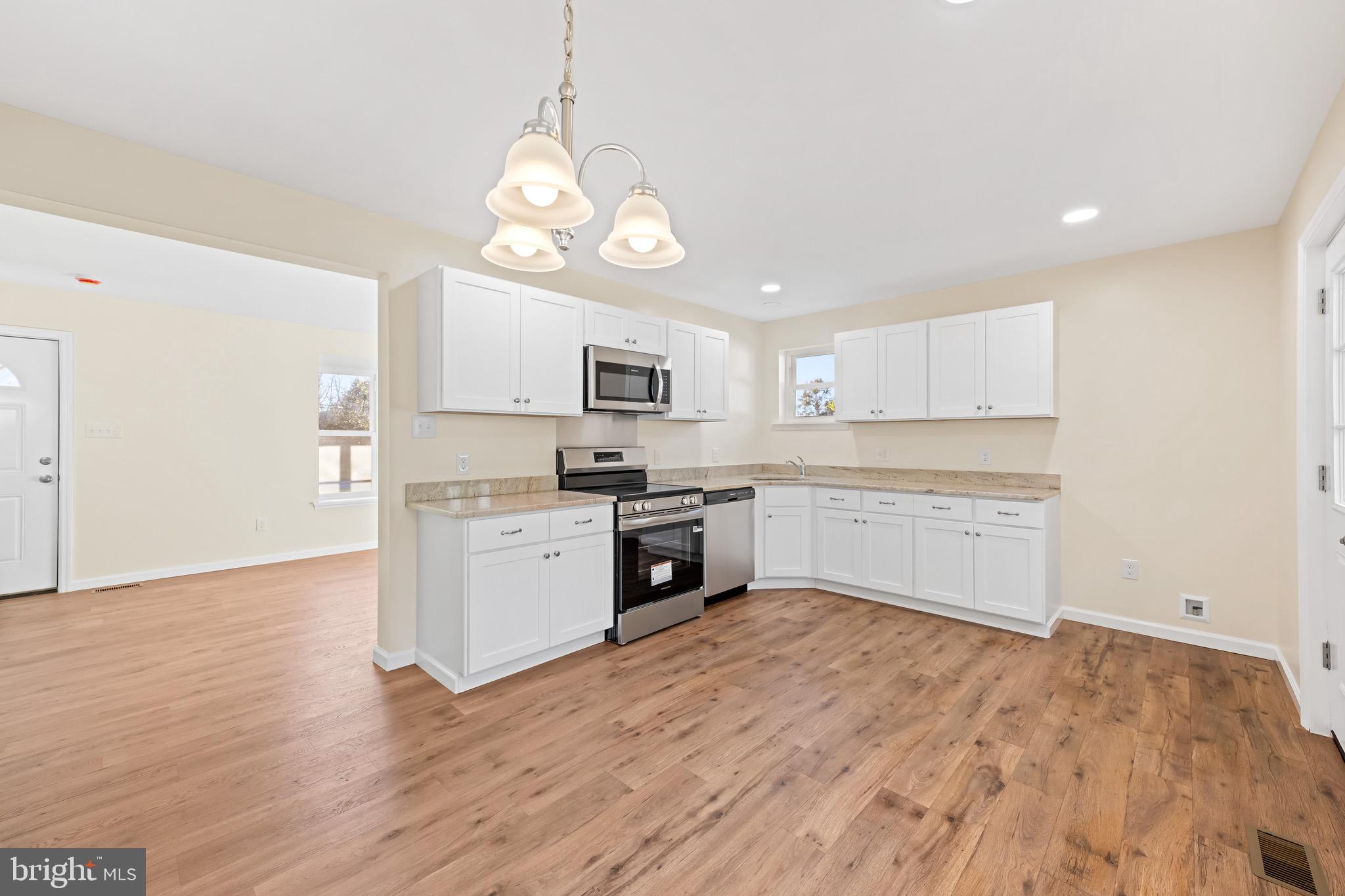 1488 North Tuckahoe Road Williamstown, NJ 08094 - Photo 7 of 27 a large kitchen with cabinets wooden floor and stainless steel appliances
