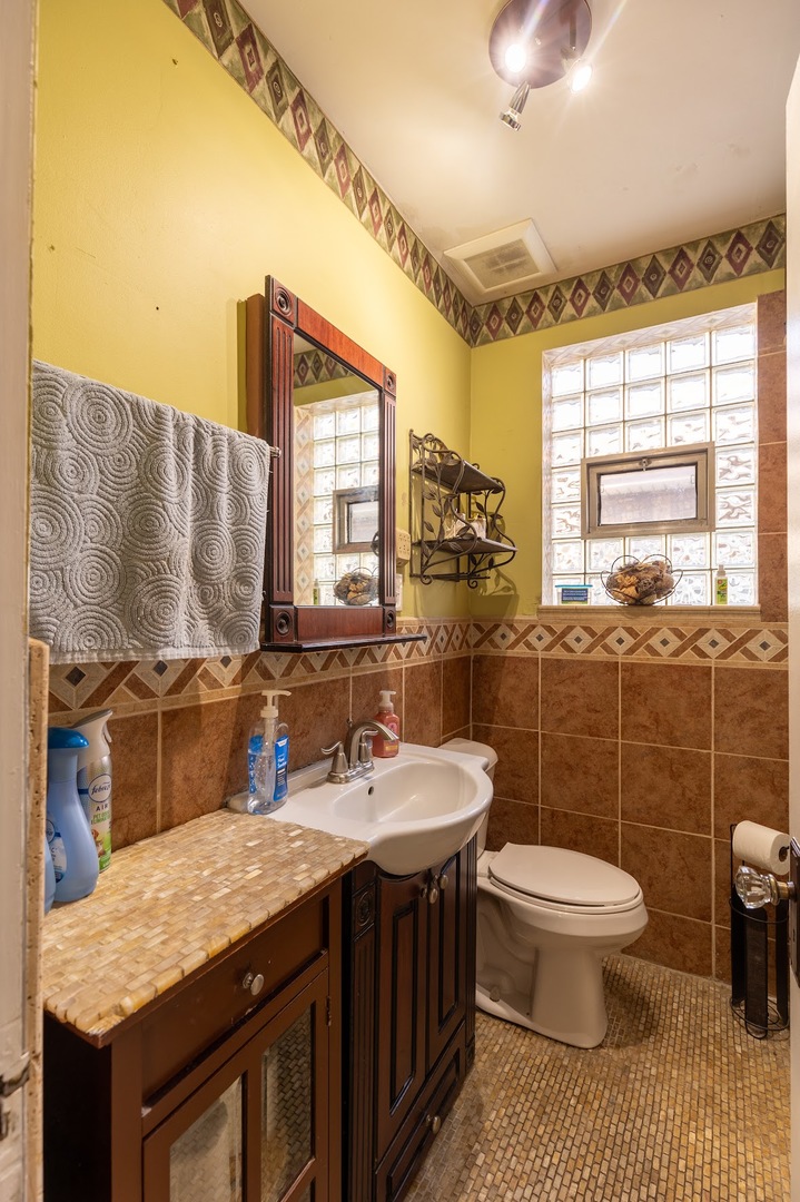 6840 29th Place Berwyn, IL 60402 - Photo 16 of 32 a bathroom with a granite countertop sink a toilet and a mirror
