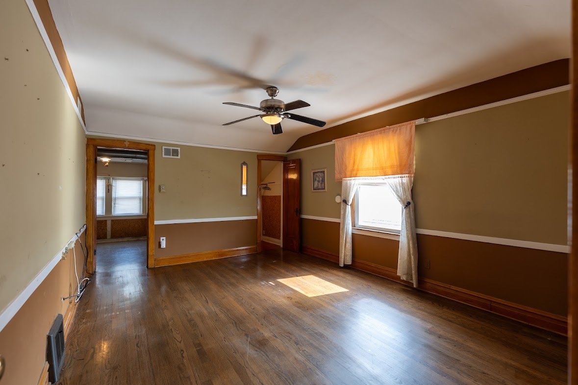 6840 29th Place Berwyn, IL 60402 - Photo 20 of 32 a view of a room with wooden floor a ceiling fan and windows