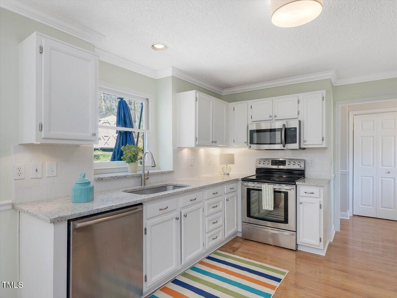 4818 Glendarion Drive Durham, NC 27713 - Photo 25 of 44 a kitchen with stainless steel appliances granite countertop a sink and a stove