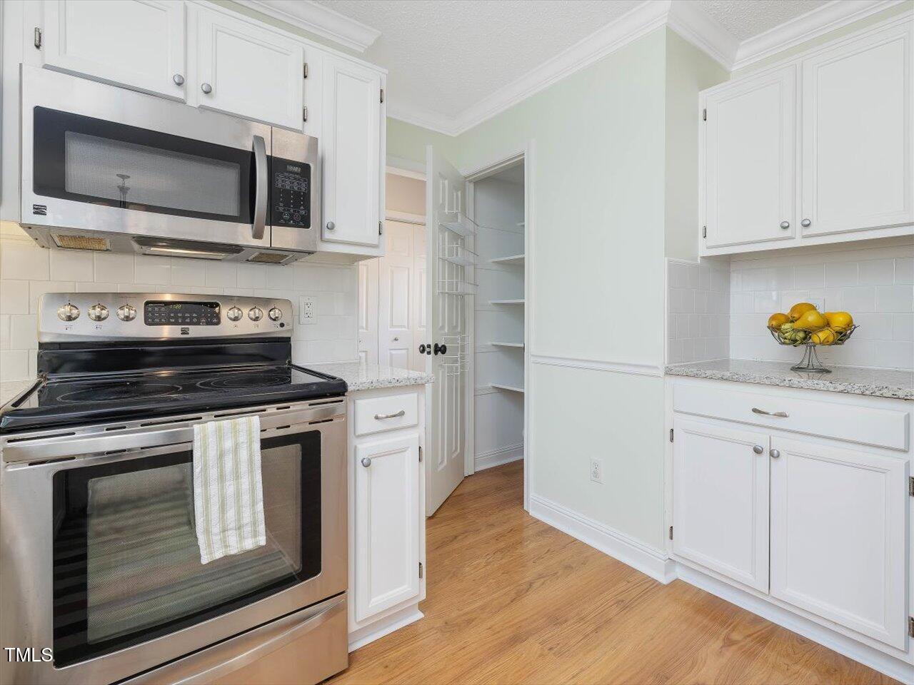 4818 Glendarion Drive Durham, NC 27713 - Photo 26 of 44 a kitchen with stainless steel appliances a stove microwave and cabinets