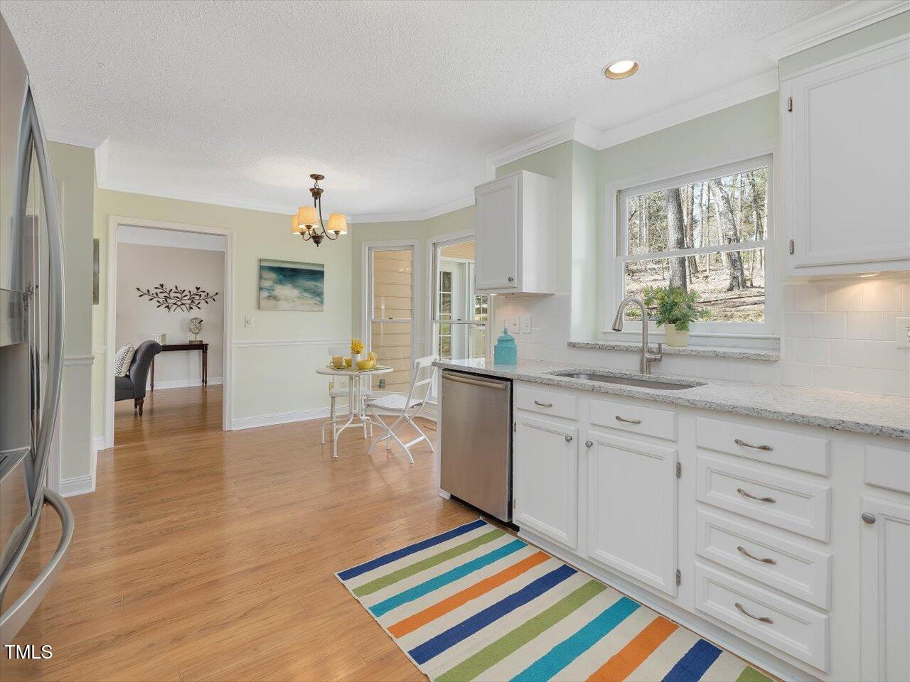 4818 Glendarion Drive Durham, NC 27713 - Photo 27 of 44 a kitchen with white cabinets and sink