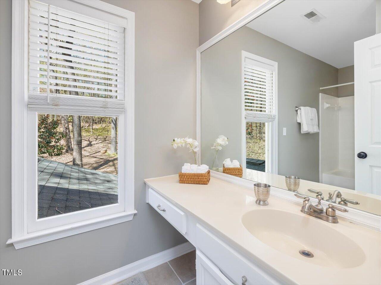4818 Glendarion Drive Durham, NC 27713 - Photo 33 of 44 a bathroom with a double vanity sink and mirror