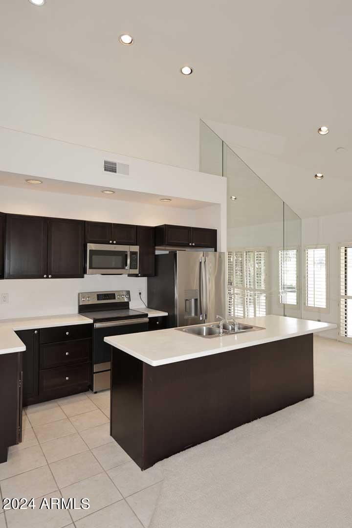 7272 East Gainey Ranch Road, Unit 55 Scottsdale, AZ 85258 - Photo 17 of 35 a kitchen with stainless steel appliances a sink stove and cabinets