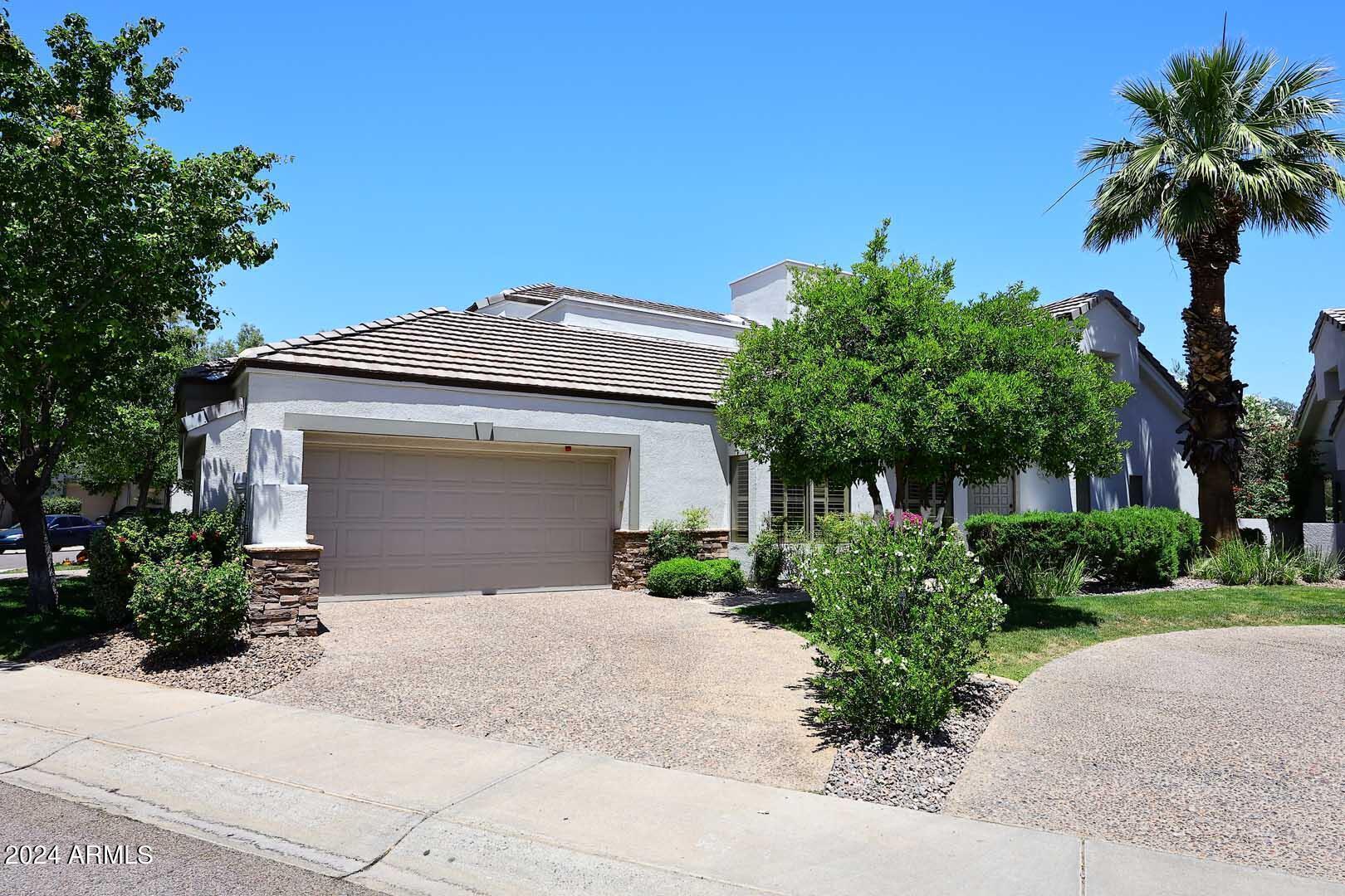7272 East Gainey Ranch Road, Unit 55 Scottsdale, AZ 85258 - Photo 2 of 35 a front view of a house with a yard and garage