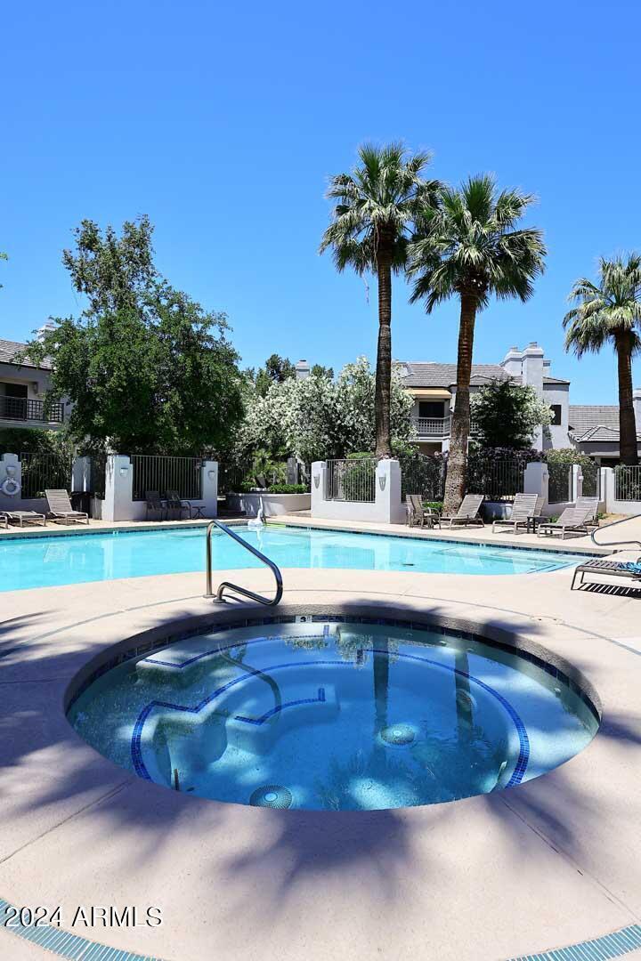 7272 East Gainey Ranch Road, Unit 55 Scottsdale, AZ 85258 - Photo 35 of 35 a view of swimming pool with a yard and palm trees