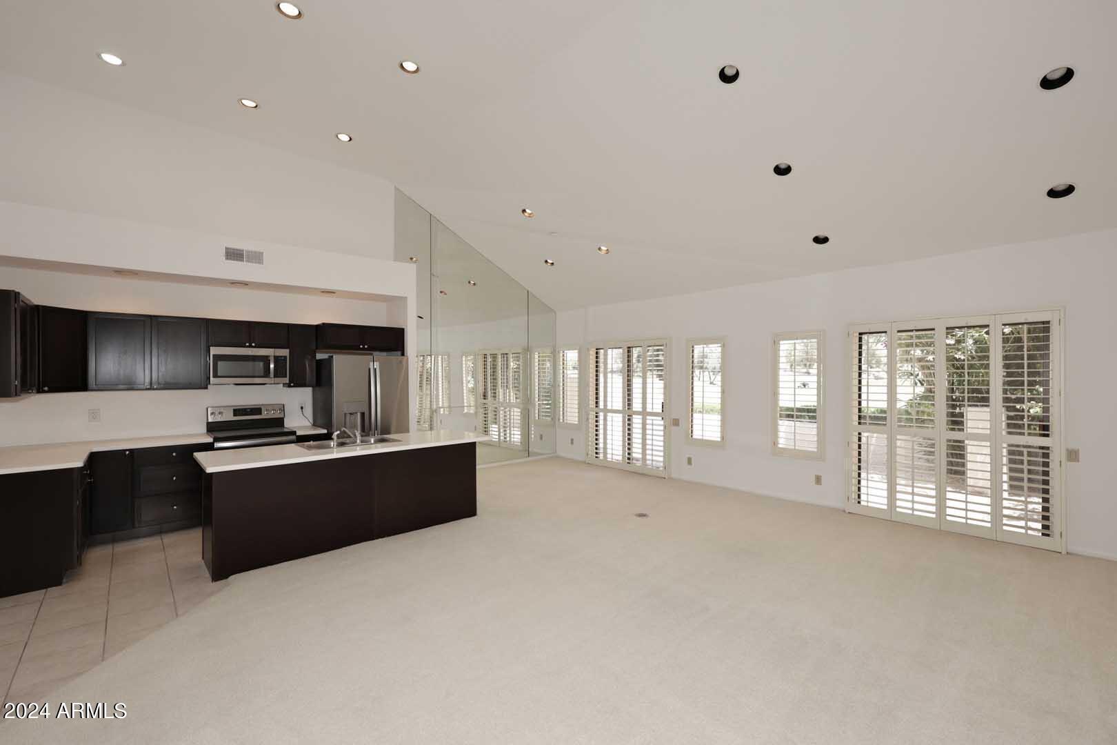 7272 East Gainey Ranch Road, Unit 55 Scottsdale, AZ 85258 - Photo 7 of 35 a large kitchen with stainless steel appliances a large counter top a stove and a sink