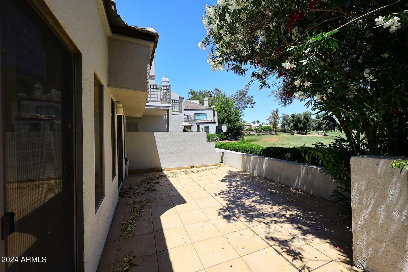 7272 East Gainey Ranch Road, Unit 55 Scottsdale, AZ 85258 - Photo 10 of 35 a view of a patio with a table and chairs a fire pit and a large tree