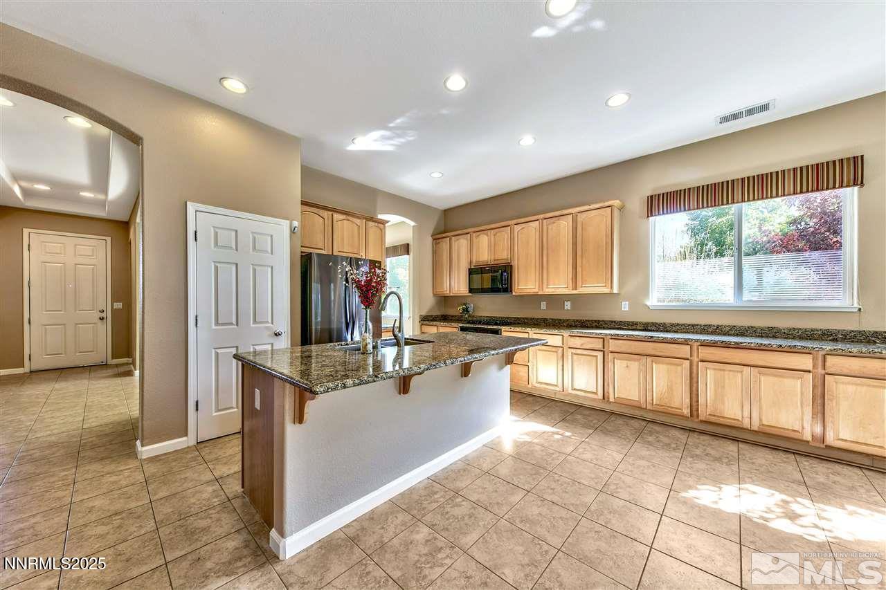 1830 Kodiak Circle Reno, NV 89511 - Photo 14 of 27 a large kitchen with kitchen island granite countertop a large window and a refrigerator