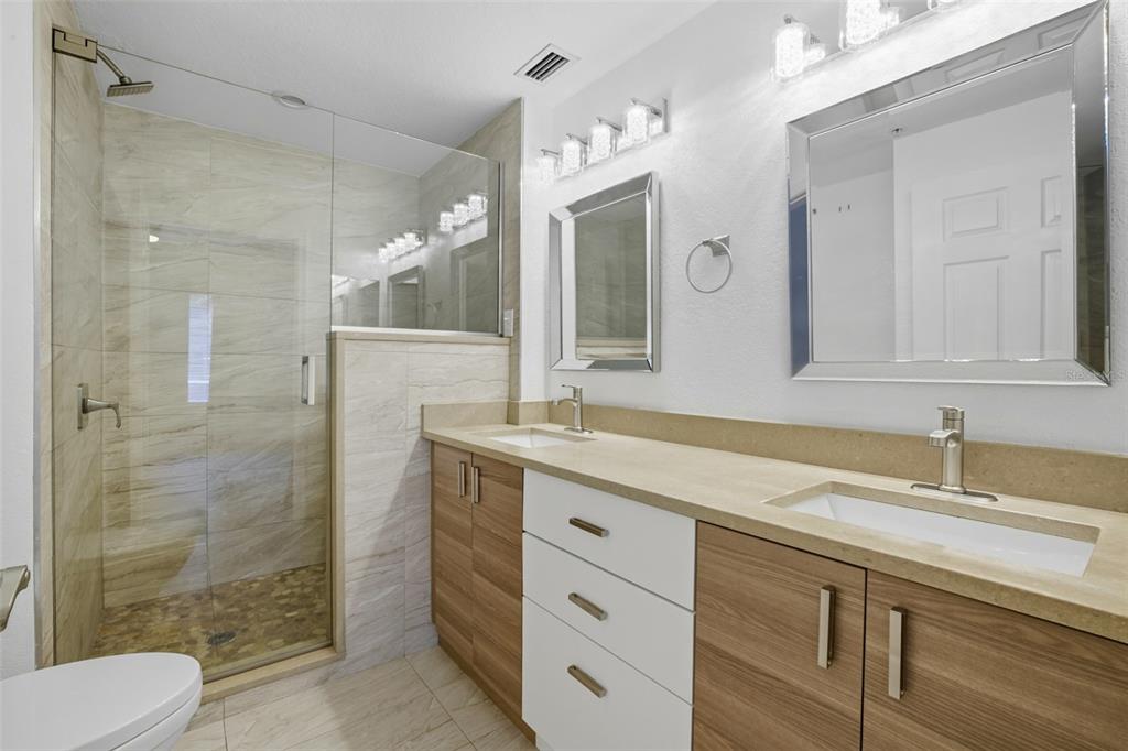 6401 Aragon Way, Unit 103 Fort Myers, FL 33966 - Photo 21 of 40 a bathroom with a sink and a mirror a toilet and shower