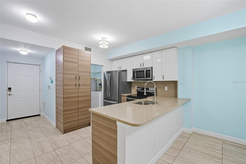 6401 Aragon Way, Unit 103 Fort Myers, FL 33966 - Photo 4 of 40 a kitchen with stainless steel appliances a refrigerator sink and microwave