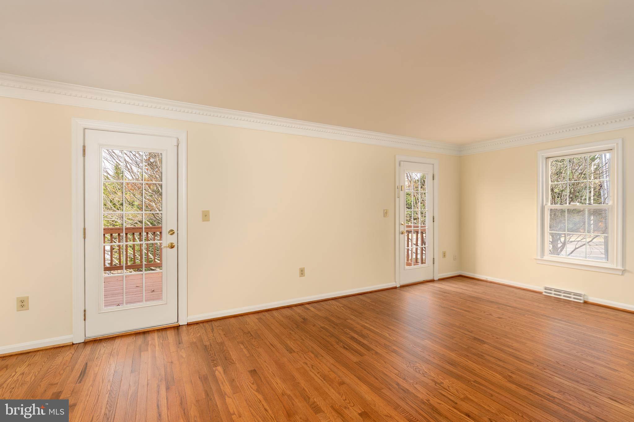 8010 Merry Oaks Lane Vienna, VA 22182 - Photo 12 of 33 an empty room with wooden floor and windows