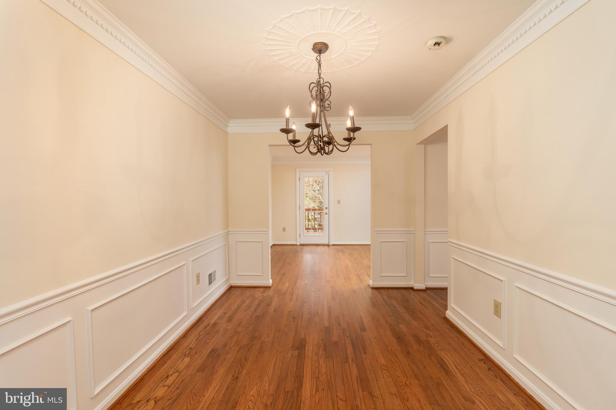 8010 Merry Oaks Lane Vienna, VA 22182 - Photo 15 of 33 a hallway with wooden floor chandelier and entryway