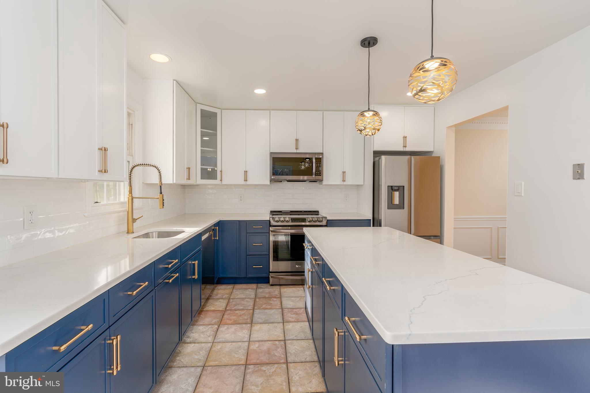 8010 Merry Oaks Lane Vienna, VA 22182 - Photo 3 of 33 a kitchen with stainless steel appliances granite countertop a sink a stove a refrigerator a center island a stove and cabinets