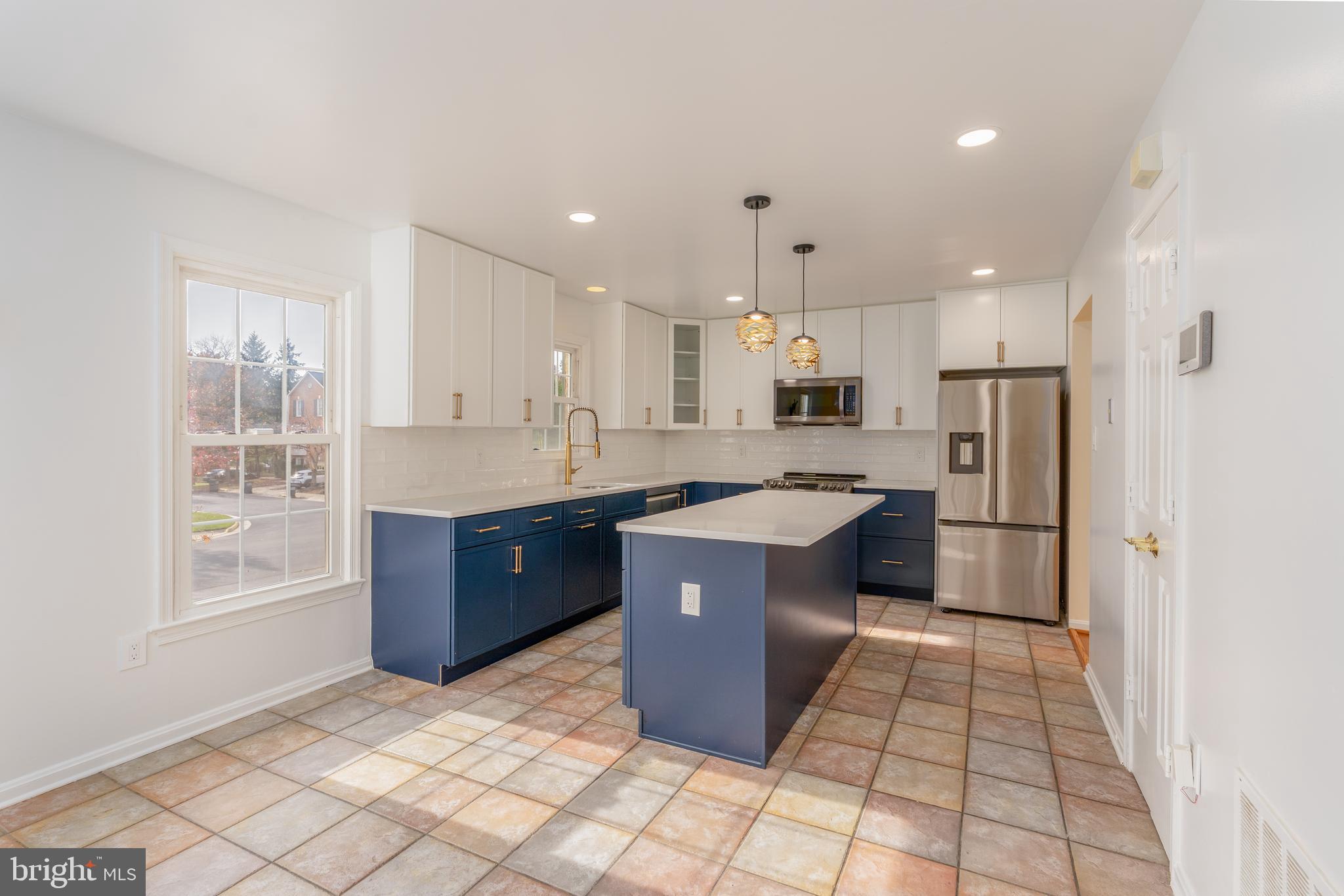 8010 Merry Oaks Lane Vienna, VA 22182 - Photo 6 of 33 a kitchen with stainless steel appliances granite countertop a refrigerator a sink a stove a microwave and island