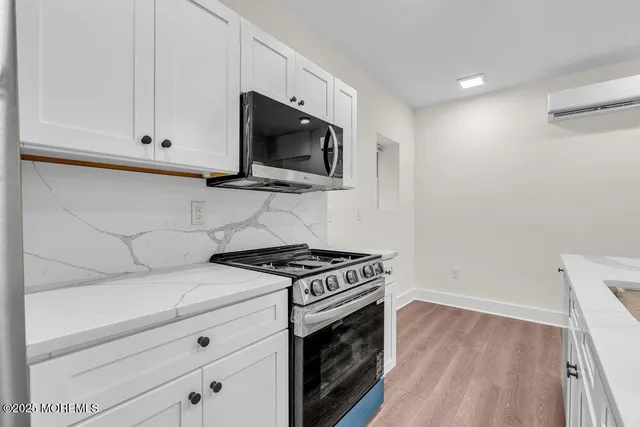 a kitchen with stainless steel appliances white cabinets and a stove top oven