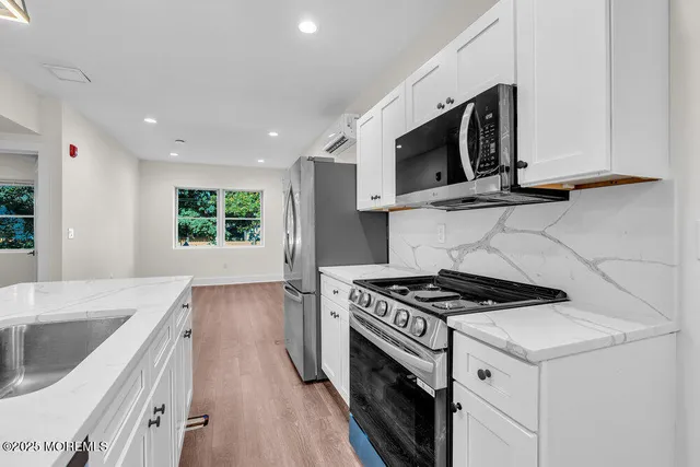 a kitchen with stainless steel appliances granite countertop a stove a microwave and a sink