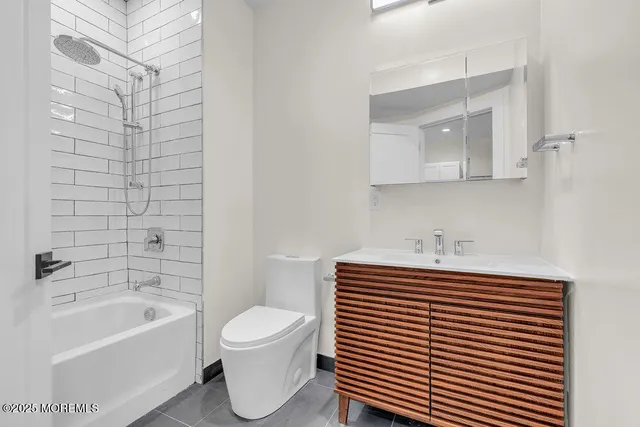 a bathroom with a sink toilet a mirror and bathtub
