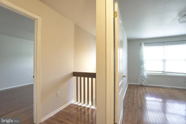 a view of a hallway with wooden floor and stairs