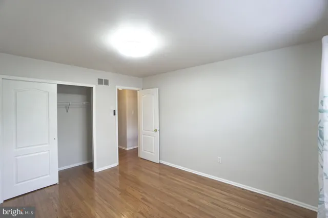 a view of an empty room with wooden floor